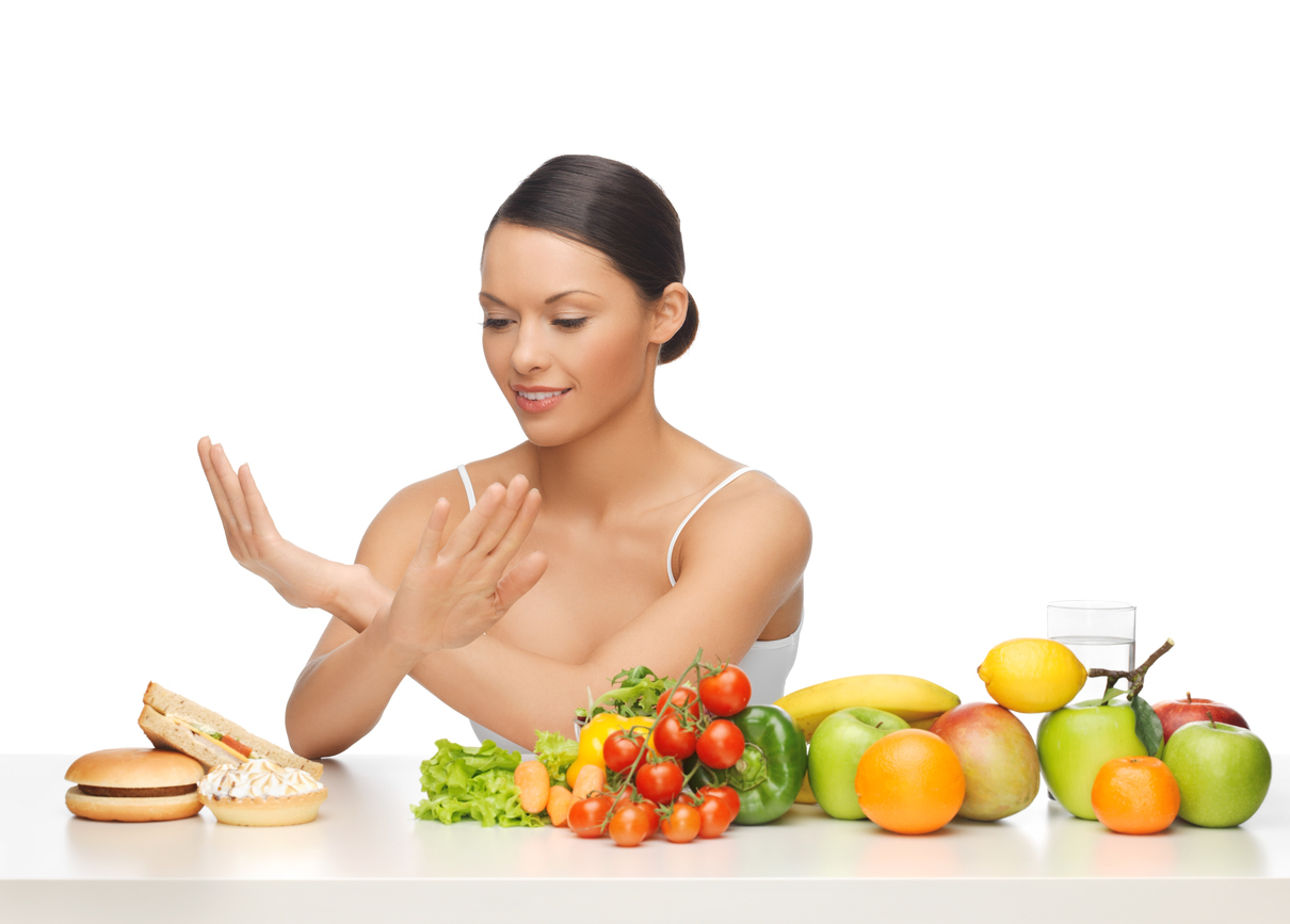 woman with fruits rejecting hamburger
